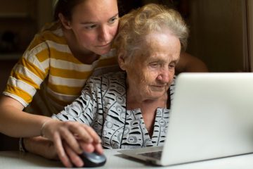 F21C7N Young girl teaches her grandmother to work on the computer.
